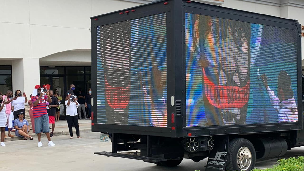 Este camión con pantallas proyecta imágenes de George Floyd como pinturas y fotografías.