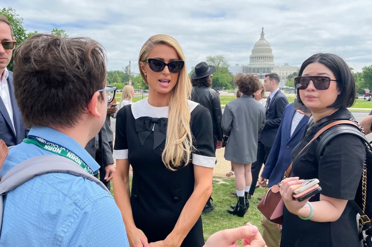 Paris Hilton, en el centro, hablando con un partidario en un evento de Stop Institutional Child Abuse, el miércoles 11 de mayo de 2022 en Washington. Hilton se encuentra en Washington defendiendo los esfuerzos para mejorar la protección de los jóvenes en programas e instalaciones residenciales.