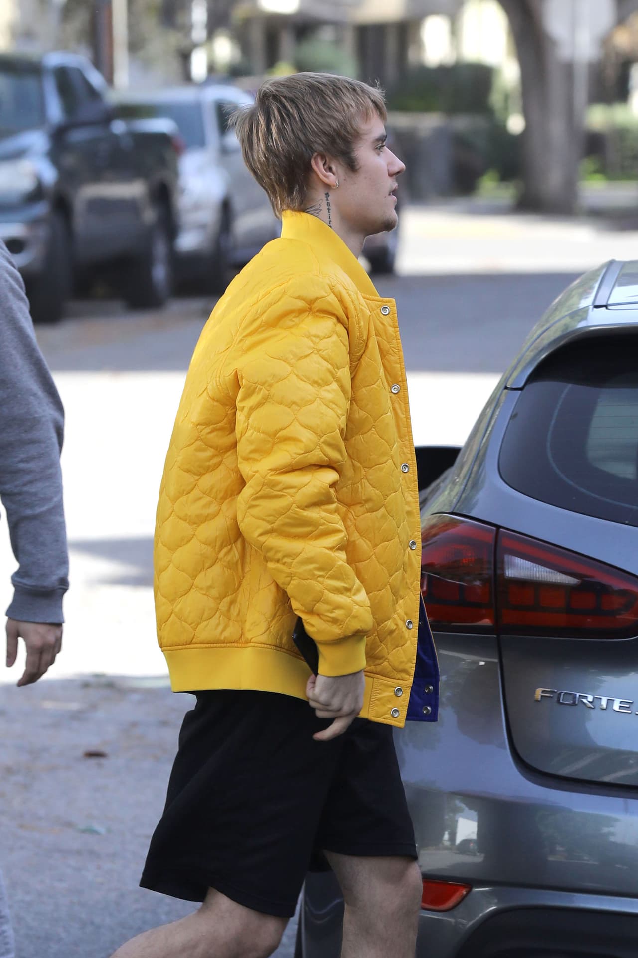 Y con shorts negros y una chaqueta amarilla, salió de su camioneta hacia un local.