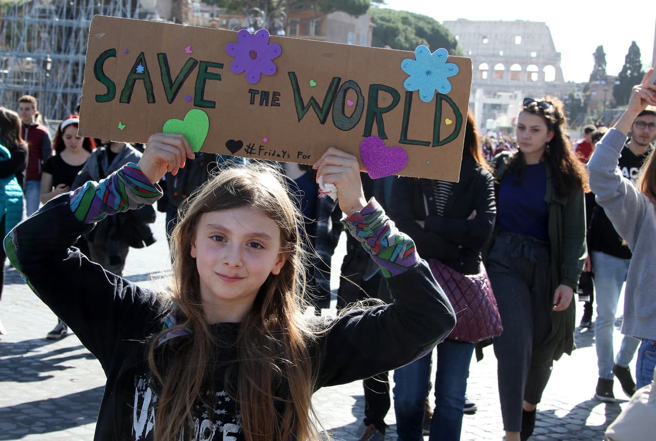 <b>Roma, Italia.</b> "Salvemos el mundo" se lee en el cartel que lleva la estudiante. Allí miles de estudiantes comenzaron su protesta en el Coliseo antes de marchar por el centro histórico de la ciudad.