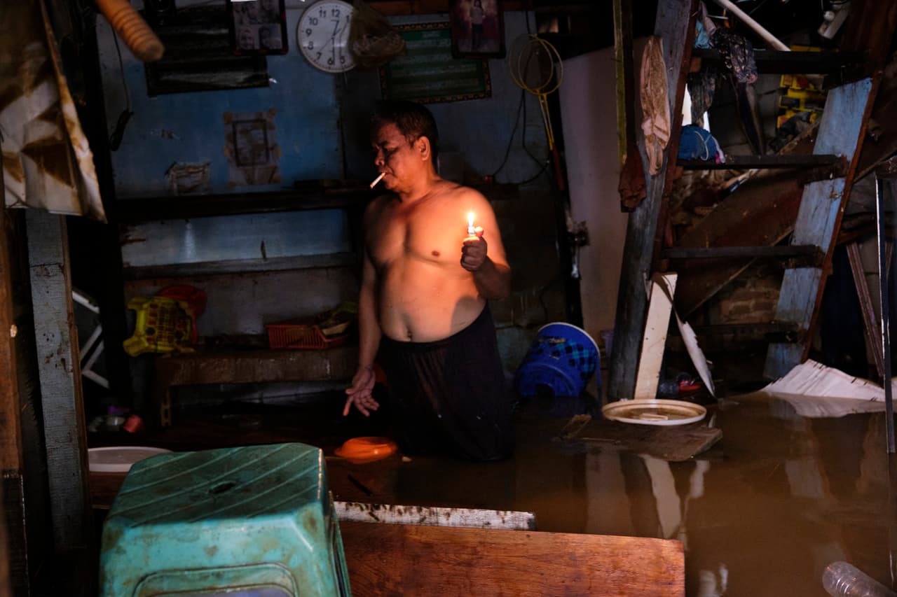 Un residente de Yakarta inspecciona su tienda y los destrozos que causó la inundación, la peor que haya sufrido Indonesia en años.