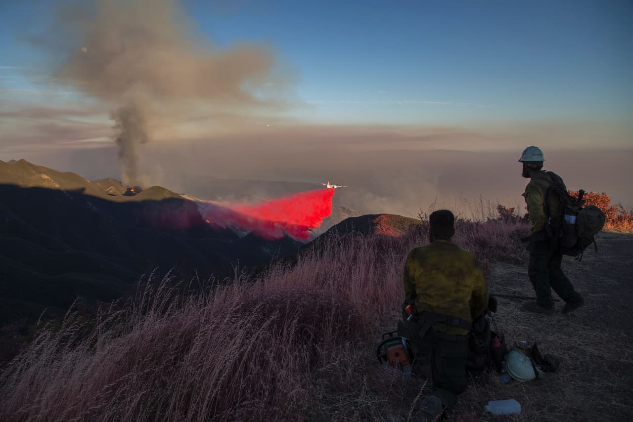 Un jet de los bomberos deja caer espuma retardante en el parque Los Padres en Santa Bárbara.
