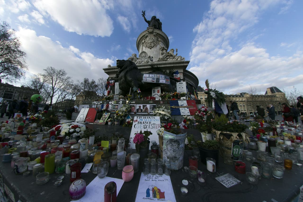 Velas, flores y dibujos hechos por el dibujante francés Plantu, en la Plaza de la República en París.