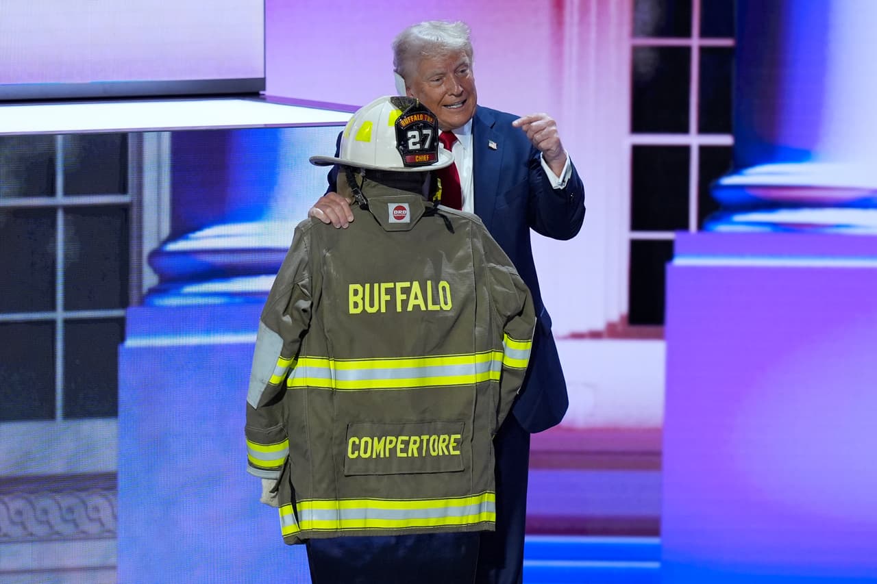 El candidato presidencial republicano Donald Trump posa junto al uniforme de Corey Comperatore, el hombre que murió en el ataque contra el expresidente durante un rally de campaña.