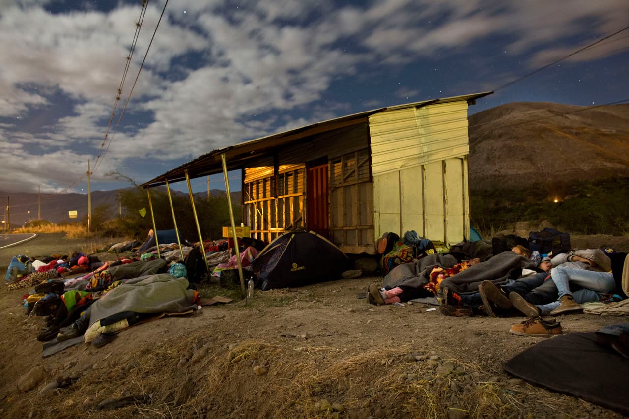 Un grupo de migrantes venezolanos, que salieron en caminata hacia Perú, duermen en Mascarilla, a la espera de los buses que les van a llevar a la frontera de Huaquillas.