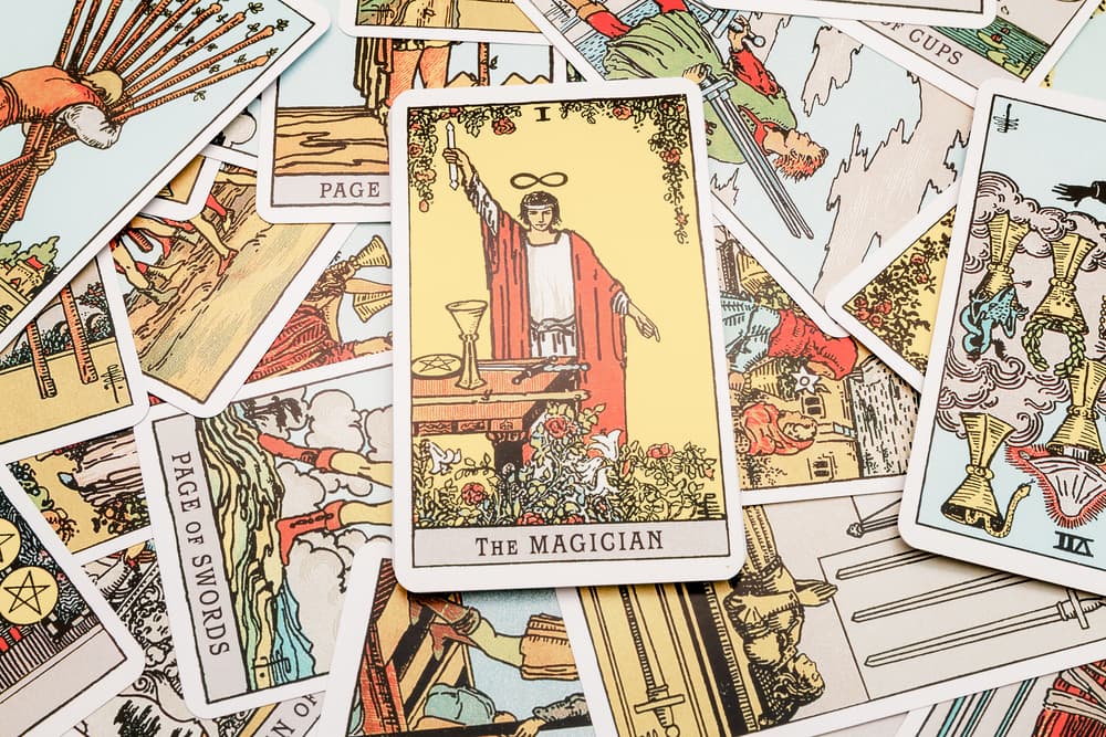 En la representación más famosa de la carta, vemos a un hombre de pie, frente a una mesa. Sobre ella hay una copa de oro, una moneda de oro y una espada. Él sostiene en su mano derecha una vara o cetro de madera, que equivale a los bastones. Así, en realidad tiene a su disposición los 4 elementos o los cuatro palos de la baraja.