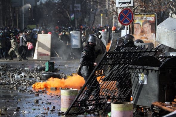 La policía ucraniana cercó hoy a los manifestantes en el corazón de las protestas opositoras de la plaza de la Independencia de Kiev (Maidán), tras una jornada en la que murieron 14 personas en los disturbios que estallaron en la capital. Víktor "Yanukóvich se ha convertido en un presidente sangriento", aseguró hoy el dirigente opositor Vitali Klitschkó en un llamamiento a los países democráticos para que intervengan en Ucrania y frenen la violenta confrontación. Según se acercaba la medianoche, los temidos Berkut, el destacamento antidisturbios, estrechaban el cerco en torno a los miles de manifestantes concentrados en el Euromaidán, bastión de las protestas desde el pasado 21 de noviembre. "Los extremistas de la oposición han cruzado la línea roja; matan a inocentes en la calles de la capital de Ucrania, vejan a mujeres, queman edificios y automóviles. Y si los disturbios continúan, nos veremos obligados a actuar con firmeza", rezaba el ultimátum del Servicio de Seguridad y el Ministerio del Interior de Ucrania. Advierten a los americanos que se queden dentro de las casas y de nuevo se sienten explosiones en la ciudad.