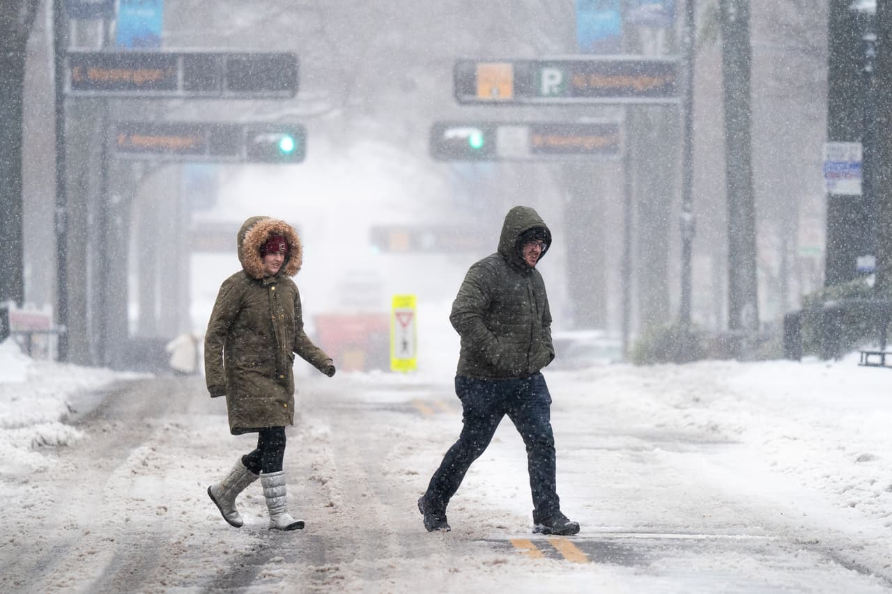 La tormenta de invierno 
<b>arrojó hasta 10 pulgadas de nieve</b> en algunas áreas del oeste de Carolina del Norte, detalló Brian Hurley, meteorólogo del Weather Prediction Center en College Park, Maryland. En la fotografía, dos personas cruzan la calle en Greenville, Carolina del Sur.