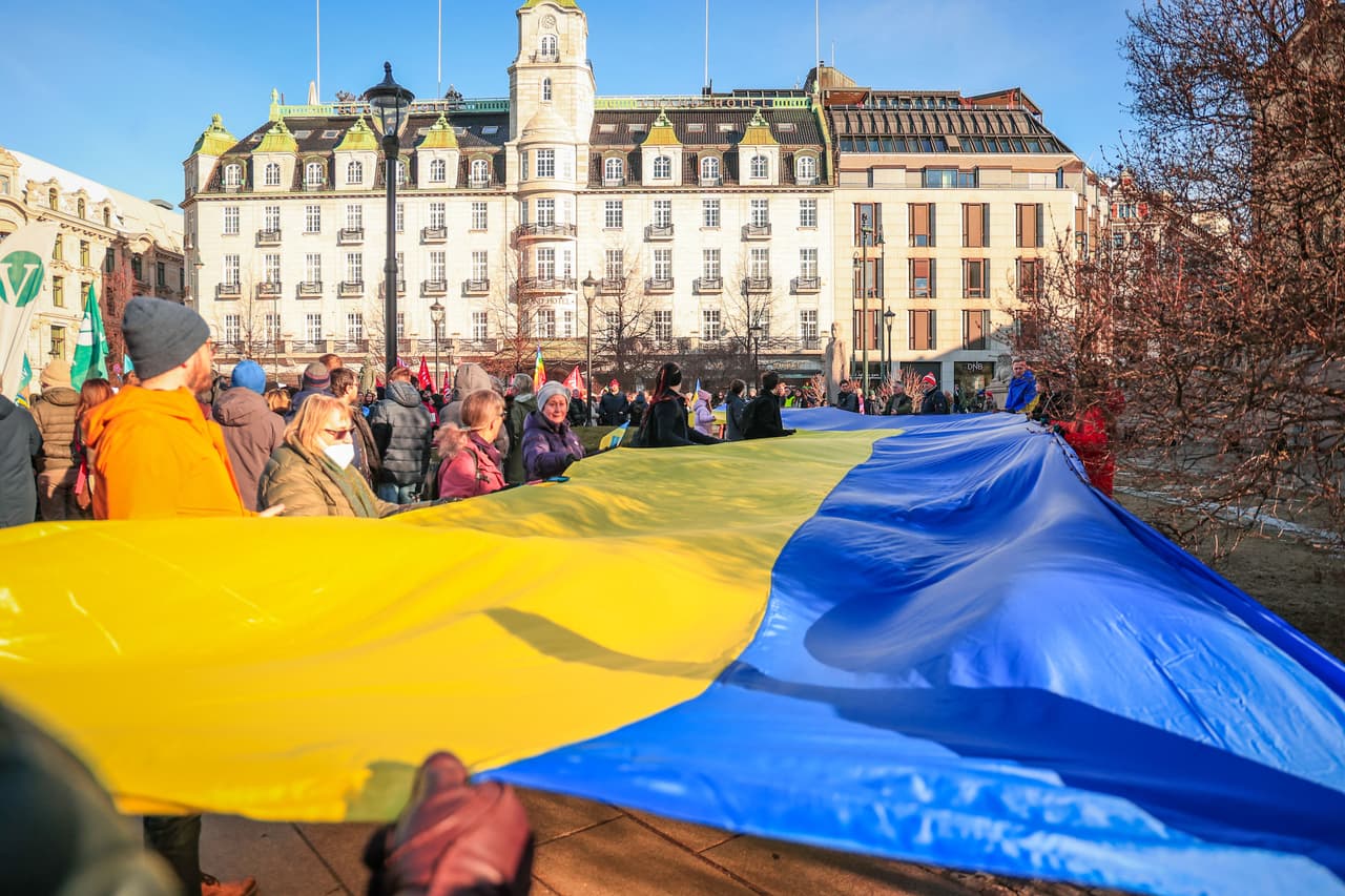 Una gran bandera ucraniana es sostenida
<b>por diversos manifestantes durante una protesta frente al Parlamento noruego en la capital, Oslo.</b>