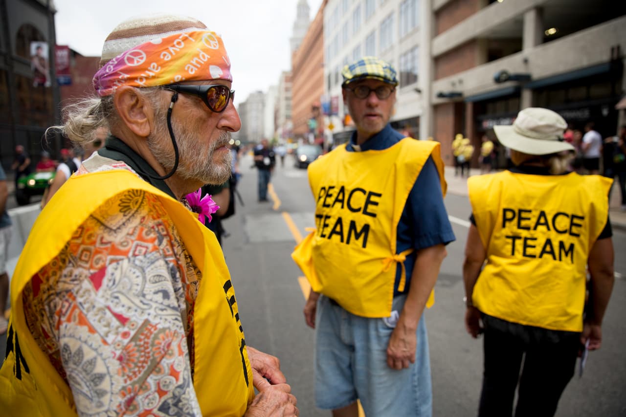 LUNES 18 DE JULIO. 2:03 PM. Con sus característicos chalecos amarillos, el Peace Team formó parte de la multitud que marcho en el centro de Cleveland. Este grupo, junto a Amnistía Internacional, están presentes en la ciudad monitorear las protestas y los derechos humanos de los participantes. Afirman que también estarán en Philadelphia la próxima semana en el la convención demócrata.