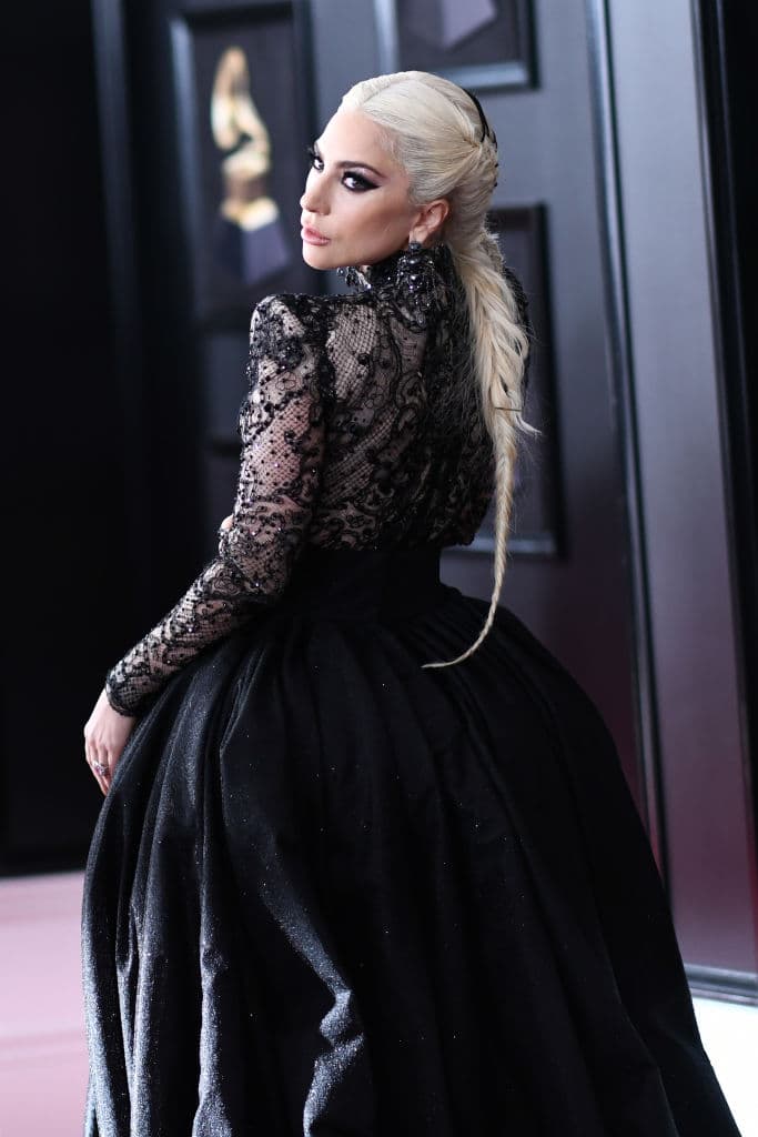 En la entrega del GRAMMY 2018, 
<b>Lady Gaga</b> acudió con un vestido negro personalizado Armani Privé de encaje y con una cola tan larga que necesitaba personas que la acompañaran en la alfombra roja.