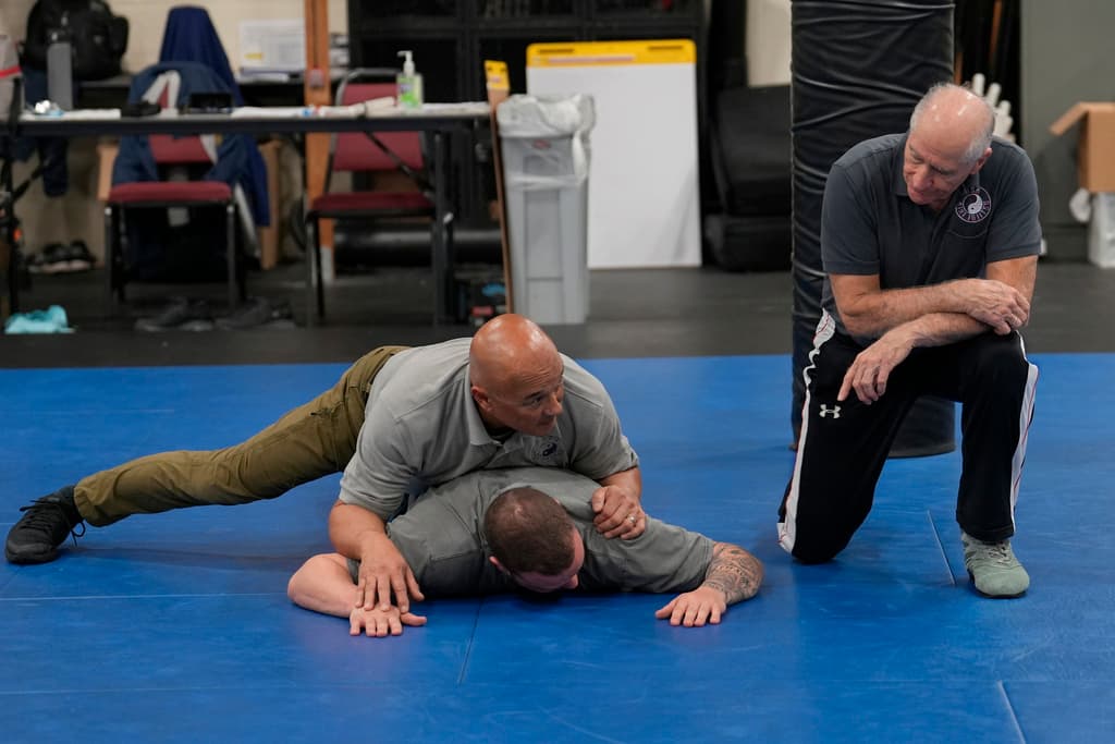 El instructor Dave Rose, a la derecha, observa cómo su compañero instructor Enrico Solomon, arriba, demuestra los conceptos básicos del control terrestre a un estudiante durante un curso de Instructor de Arresto y Control en Sacramento, California, el jueves 18 de enero de 2024. Agentes encargados de hacer cumplir la ley de Varias agencias asisten a la clase donde reciben instrucción sobre técnicas básicas de arresto y control que deben llevar a sus agencias para transmitirlas a sus compañeros oficiales.