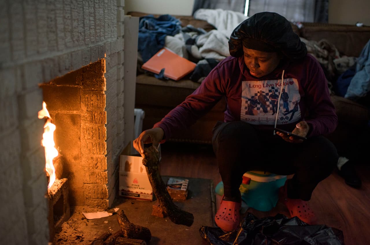 Linda McCoy, residente de Houston, arroja leña a la chimenea para calentar su casa el 17 de febrero. La poderosa tormenta invernal que azota a Texas desde la semana pasada dejó a cientos de miles sin electricidad y sin agua, causando una crisis inusual en la considerada 'capital de la energía' de Estados Unidos. 
<br>
<br> 
<br>