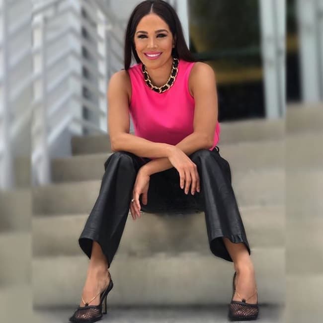 La conductora mexicana recreó la tendencia 'glam' usando una blusa rosa fucsia y un pantalón vinipiel negro.