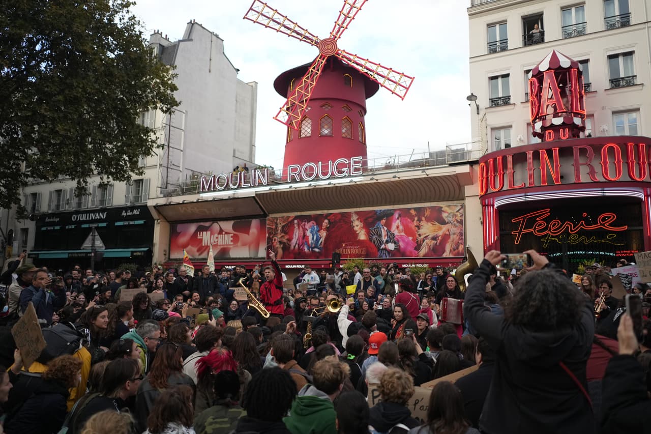 Manifestantes se congregan frente al cabaret Moulin Rouge durante una protesta contra el aumento del costo de vida, sumándose a las quejas de los estudiantes, en París, el sábado 17 de octubre de 2026.