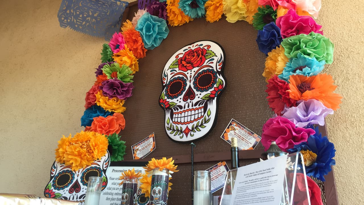 Un altar con veladoras y papeles para que las personas escribieran los nombres de sus seres queridos fallecidos.