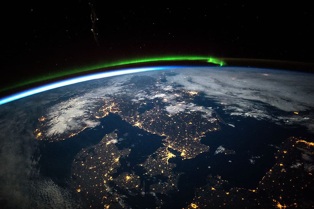 Los astronautas a bordo de la EEI tomaron esta imagen del sur de Escandinavia justo antes de la medianoche bajo luna llena. Las características más destacadas incluyen una aurora verde al norte (mitad superior de la imagen), la negrura del mar Báltico (abajo a la derecha), las nubes (arriba a la derecha) y la nieve en Noruega iluminada bajo la luna llena.