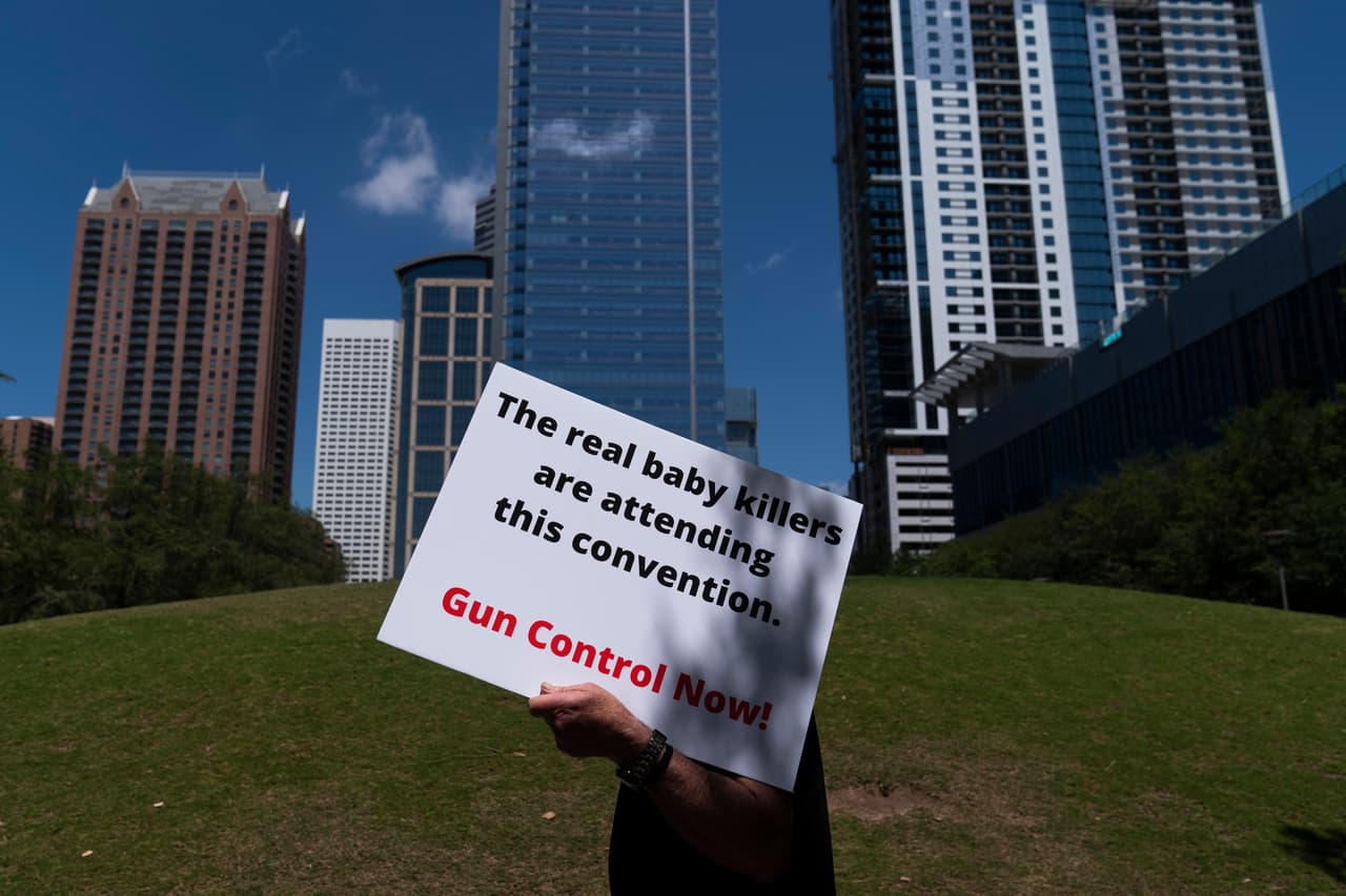 Un hombre lleva un letrero que dice: "Los verdaderos asesinos de bebés asisten a esta convención". Entre los oradores 
<a href="https://www.univision.com/noticias/estados-unidos/nra-convencion-houston-tiroteo-uvalde" target="_blank">de la cita anual de la NRA</a> está el expresidente Donald Trump y el senador por Texas Ted Cruz. El gobernador texano Greg Abbott, quien estaba previsto que participara, enviará un mensaje de video.