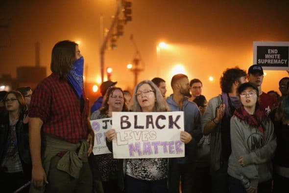 Cantando y gritando consignas, los manifestantes se unieron en oración en una iglesia local durante la madrugada antes de marchar al departamento de policía.