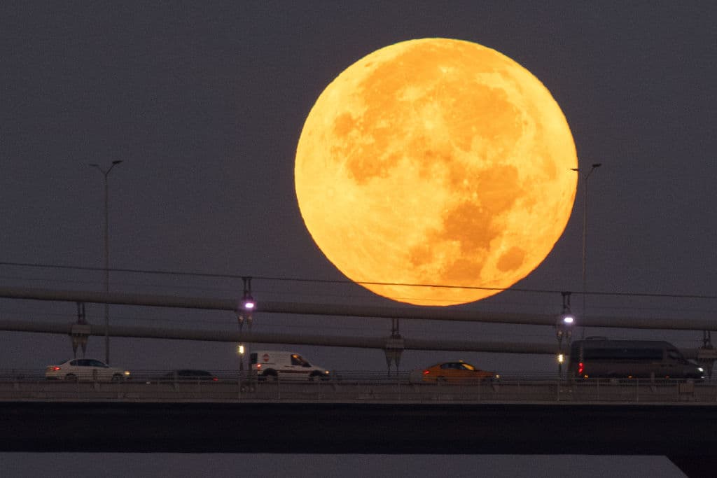 Así se vio la superluna azul de este 30 de agosto en Estambul, sobre los carros que cruzaban el Puente del Bósforo.