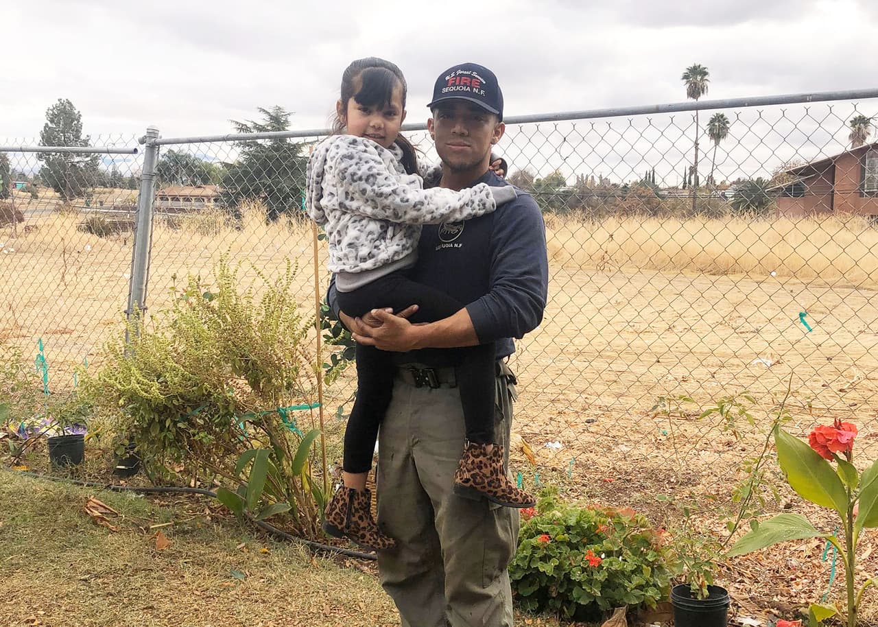 "Muchos de nosotros estamos aquí para prosperar, realizar el sueño que nuestros padres alguna vez tuvieron, una mejor forma de vida" comenta agradecido.
<br>En la imagen, Derian con su pequeña hija al volver del incendio Cave, ocurrido en Santa Barbara el año pasado.