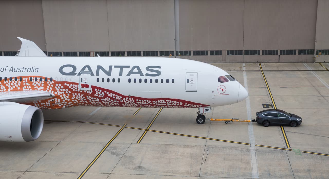 El objetivo de Qantas es
<b>reducir las emisiones de gases de efecto invernadero</b> mediante el uso de vehículos eléctricos para remolcar sus aviones.