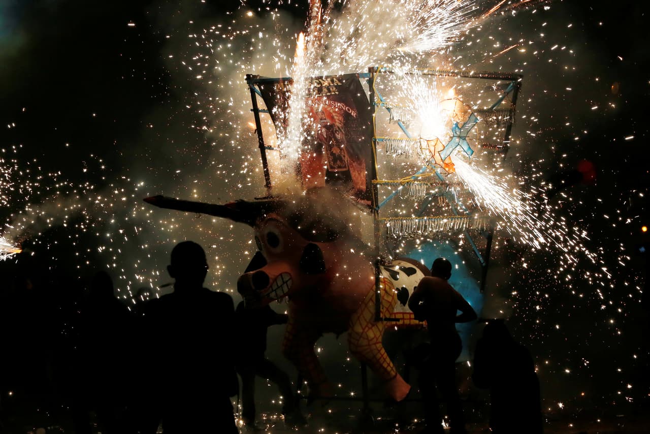 Las chispas pirotécnicas del toro envuelven a quienes fueron a celebrar a San Juan de Dios. (Reuters)
