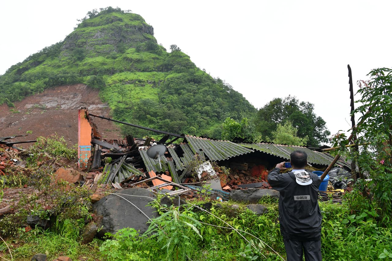Los deslaves causados por las intensas lluvias han cortado varias carreteras, sobre todo la que conecta Bombay, la capital financiera del país, y la ciudad de Goa. En la imagen, un hombre toma una foto en Taliye, al sur de Bombay, donde ocurrió un grave deslave que dejó a
<b>53 personas bajo el fango.</b>