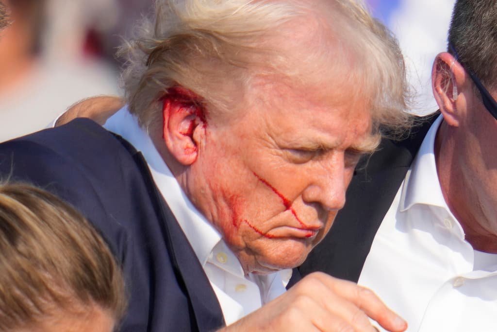 En esta imagen se puede observar a Trump con sangre en la oreja derecha mientras es escoltado para abandonar el lugar.