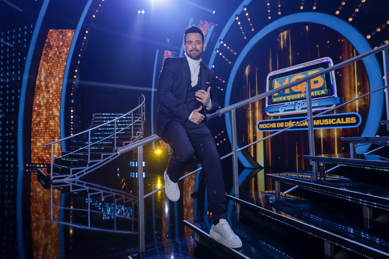 En su primer look, Mane de la Parra lució un traje azul oscuro con un suéter de cuello de tortuga blanco y unos zapatos deportivos en un tono ligeramente gris.