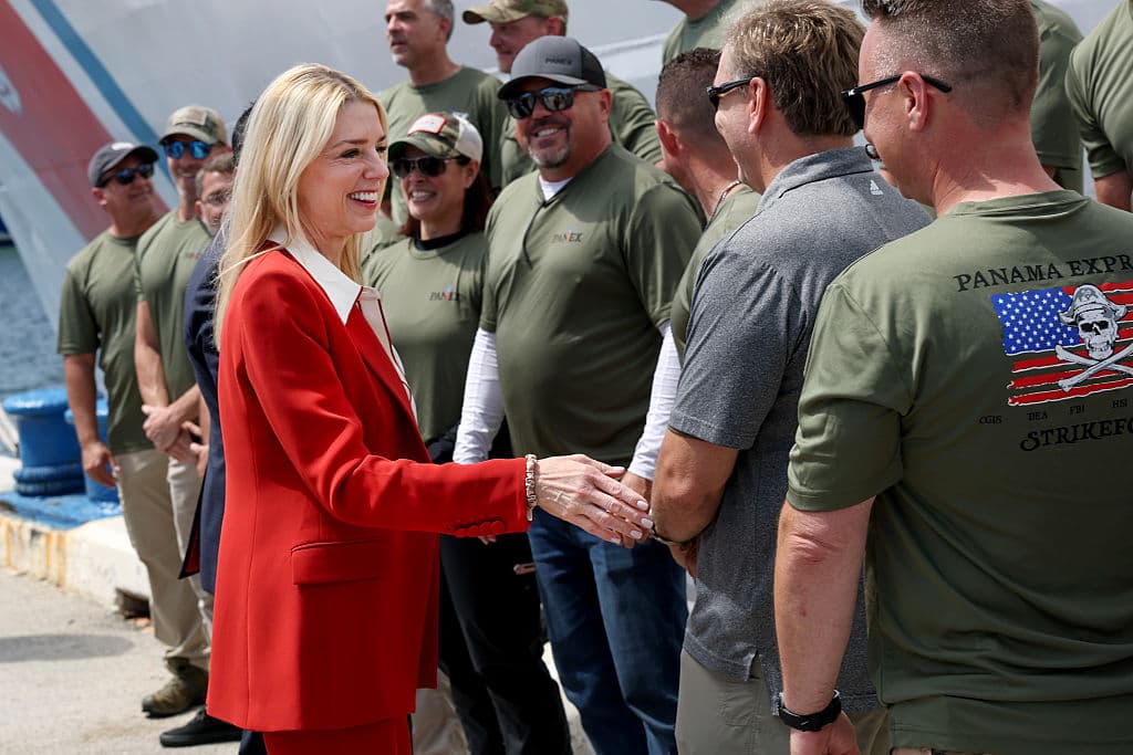 La fiscal Bondi saluda sonriente a varios efectivos que participaron en la incautación.