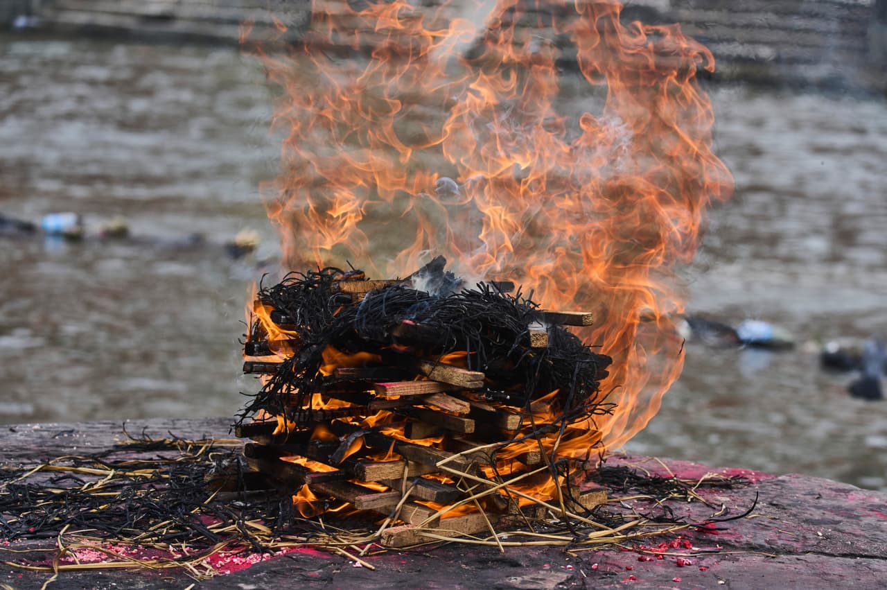 Una efigie de Ganesh Nepali, de 42 años —desaparecido tras las repentinas inundaciones—, es incinerada durante un funeral simbólico a orillas del río Bagmati en Katmandú, Nepal, el jueves 3 de septiembre de 2026. (Foto AP/Niranjan Shrestha)