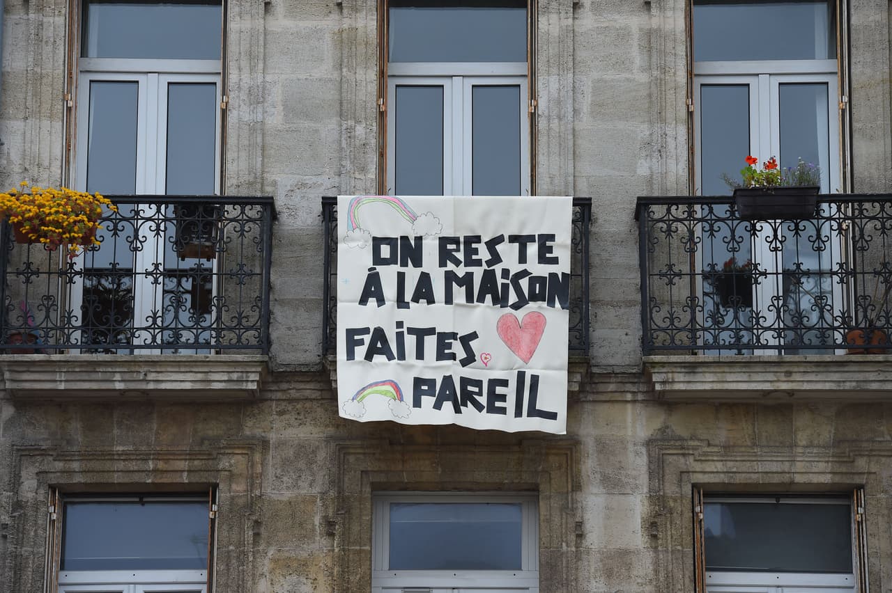 Esta foto es en Burdeos, suroeste de Francia. Una bandera colgada en un balcón que dice "Nos quedamos en casa, hagan lo mismo".