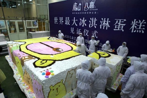 Trabajadores chinos de la ciudad de Beijing preparar un pastel de helado, con la imagen de juego para niños más grande del mundo.