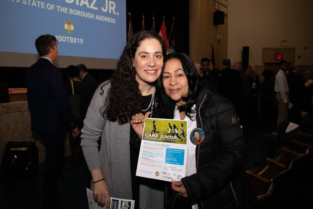 Leandra Guzmán, madre de Lesandro 'Junior' Guzmán Feliz (a la derecha), sostiene un volante del nuevo campamento de verano que lleva el nombre su hijo. Fátima Shama (a la izquierda), directora de Fresh Air.