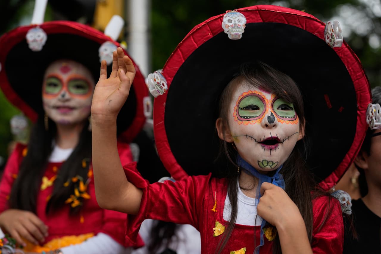Niñas saludan a los artistas durante un desfile con motivo de la Copa del Mundo, en la Ciudad de México, el 13 de junio de 2026.
