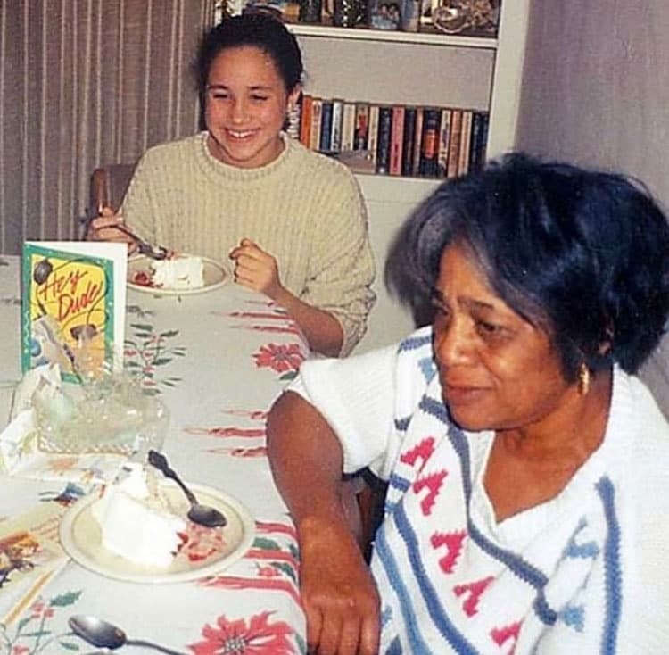 La hoy duquesa de Sussex disfrutaba las visitas a casa de 
<b>su abuela materna, Jeanette Johnson</b>, junto a quien la vemos comiendo un pedazo de pastel.
