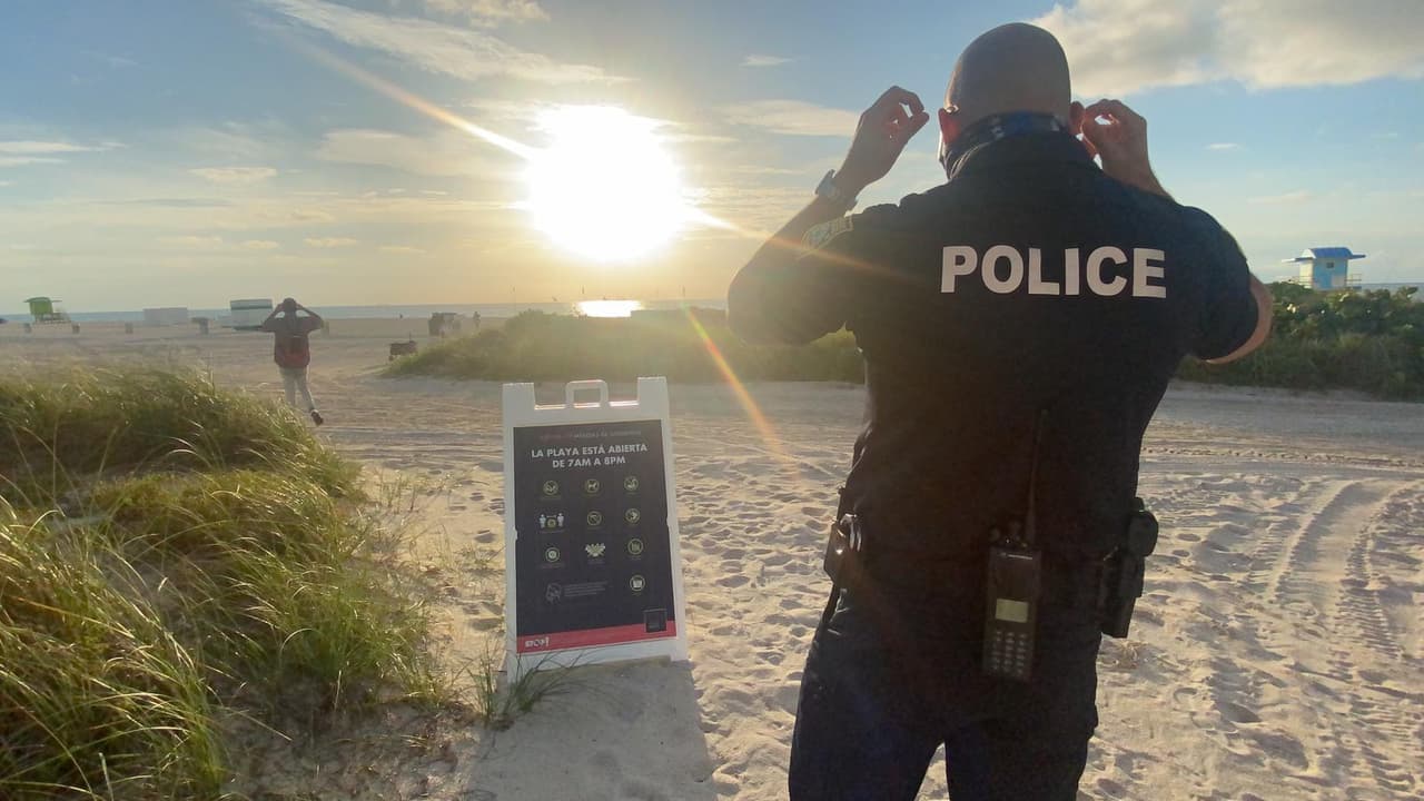 Hay policías desplegados en muchos lugares, para que las personas respeten las medidas de distanciamiento social de seis pies y utilicen las mascarillas cuando entren y salgan de la playa.