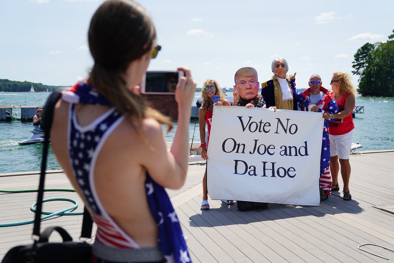 Una mujer toma una foto de un grupo de partidarios del presidente Donald Trump en el lago Lanier durante un "Great American Boat Parade"