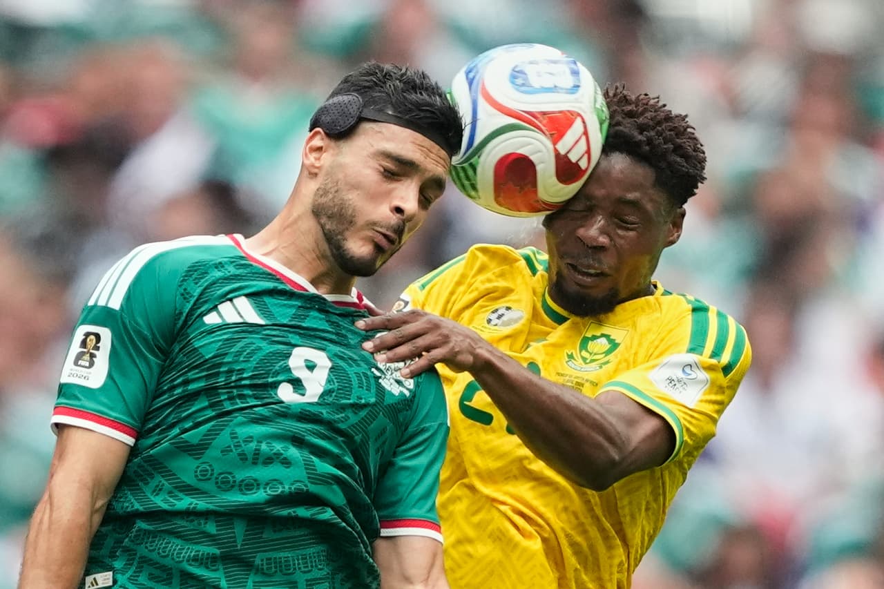 El mexicano Raúl Jiménez (izquierda) salta para disputar el balón con el sudafricano Ime Okon durante el partido de fútbol del Grupo A de la Copa del Mundo entre México y Sudáfrica.