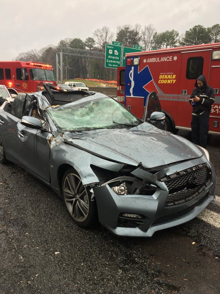 En esta imagen, el personal de rescate del Departamento de Policía de Dunwoody inspecciona un automóvil dañado por la caída de un árbol en la Interestatal 285 en Dunwoody, Georgia. No se reportaron lesiones.