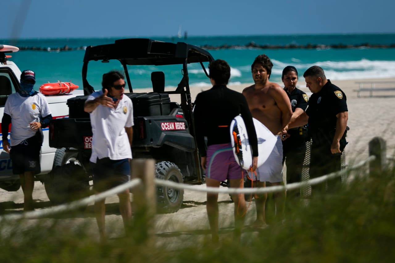 <b>Playas prohibidas</b>. Agentes de policía detienen a un hombre que entró ilegalmente en una playa cerrada en Miami Beach, Florida, el 19 de marzo. Luego de varios días de críticas, las autoridades del Miami-Dade decidieron cerrar las playas del condado, que estaban llenas de jóvenes turistas que las visitaron por las vacaciones de primavera. Este condado es el que tiene mayor número de infectados en Florida (más de 100, mientras en toda Florida hay más de 400)