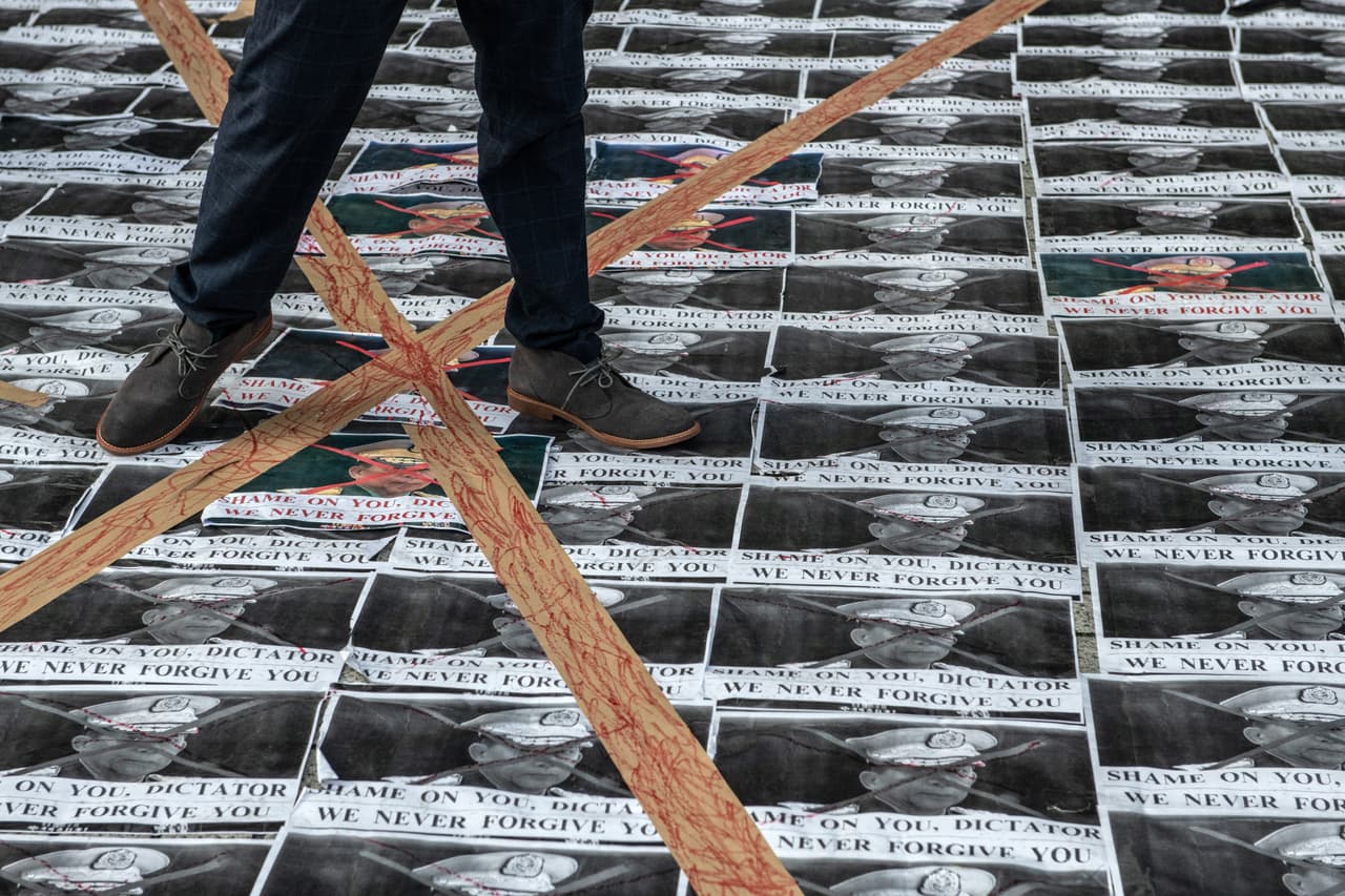 En una manifestación en Tokio, un hombre pisa fotografías del general Min Aung Hlaing, cabecilla del golpe militar que se ha producido la mañana de este lunes en Myanmar.