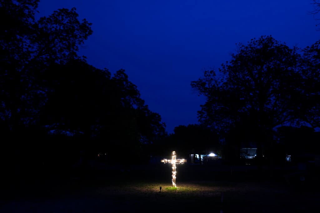 Una cruz iluminada se encuentra en un patio cercano a la escuela que perdió a sus 19 niños y 2 maestras.