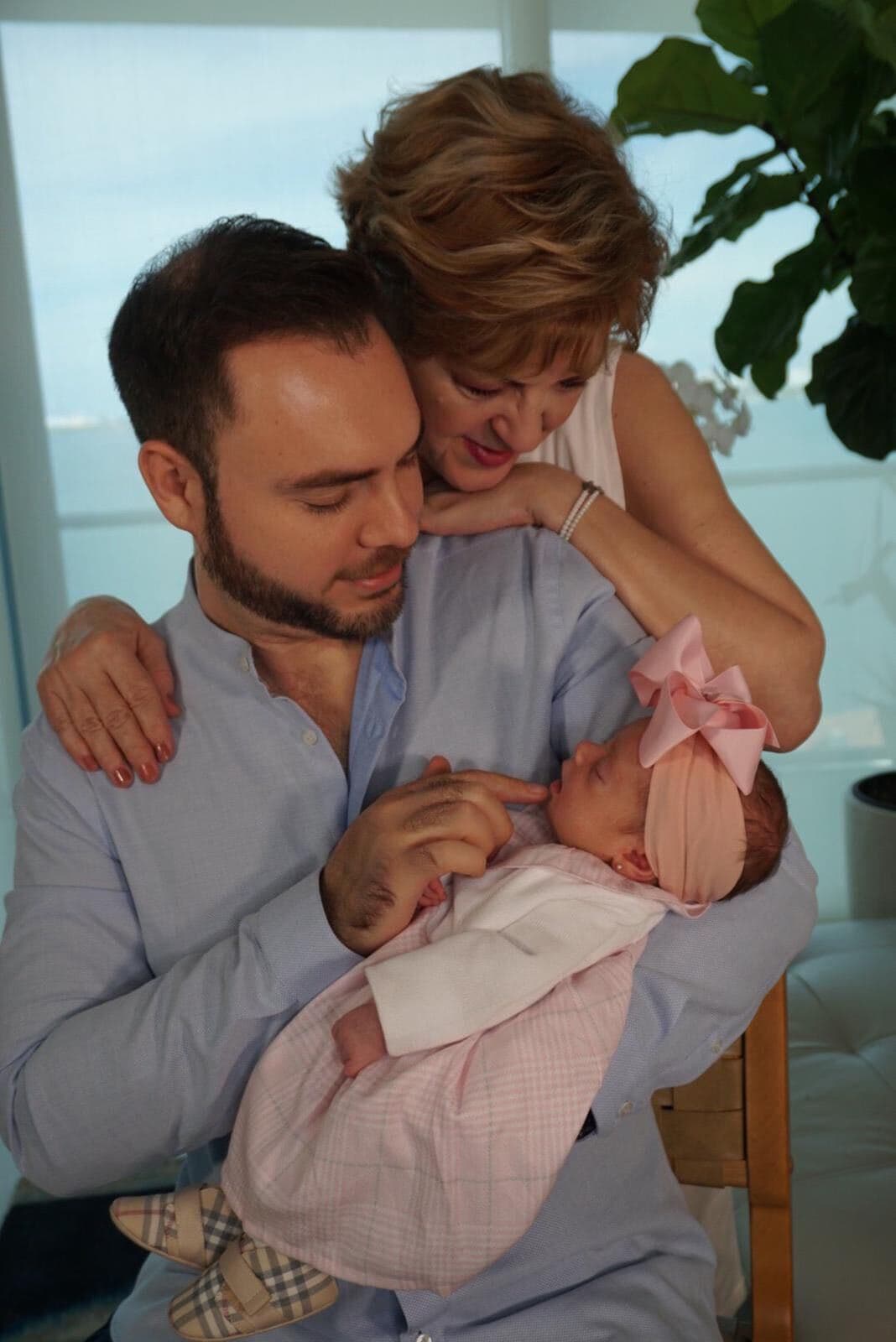 La revolución provocada por la llegada de Megan 
<b>no solo ha cambiado a la pareja, sino a todo su entorno familiar. </b>Fernando, con palabras de Michelle, "se ha ganado el mejor rol como papá del año"
<a href="https://www.univision.com/shows/primer-impacto/la-cuna-la-ropa-y-el-color-de-las-paredes-fotos-de-la-habitacion-de-la-bebe-de-michelle-galvan-fotos">disfrutando a su pequeña en todas las etapas</a>: desde cambiarle los pañales hasta vestirla". En imagen, Fernando y su madre Sandra contemplan a Megan. 
<br>