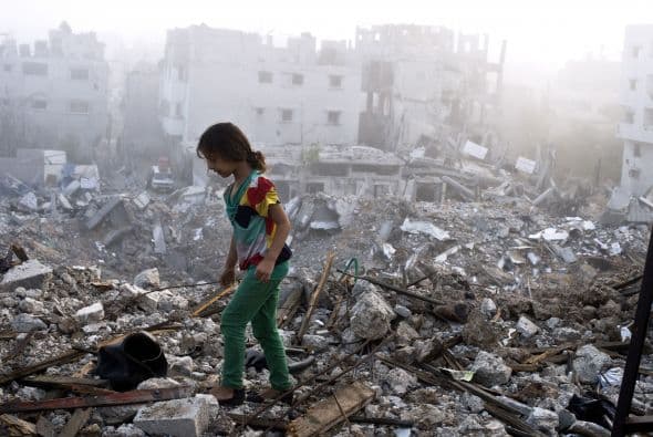 Una niña palestina camina sobre los escombros esparcidos de lo que quedó de su casa.