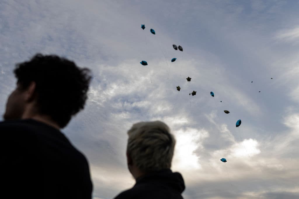 Entrada la noche, decenas de globos fueron liberados al cielo, con mensajes dedicados a las víctimas de 
<b><a href="https://www.univision.com/noticias/tiroteos/detienen-padre-presunto-atacante-tiroteo-georgia" target="_blank">un estudiante de 14 años, identificado como Colt Gray</a></b>. Este fue arrestado y será juzgado como adulto.
