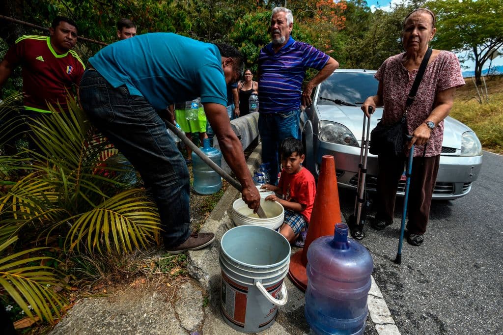 Cientos de personas buscan desesperadamente agua potable en los ríachuelos del cerro El Ávila, que rodea la ciudad de Caracas por el norte, ante la escasez generada por más de 70 horas sin electricidad.