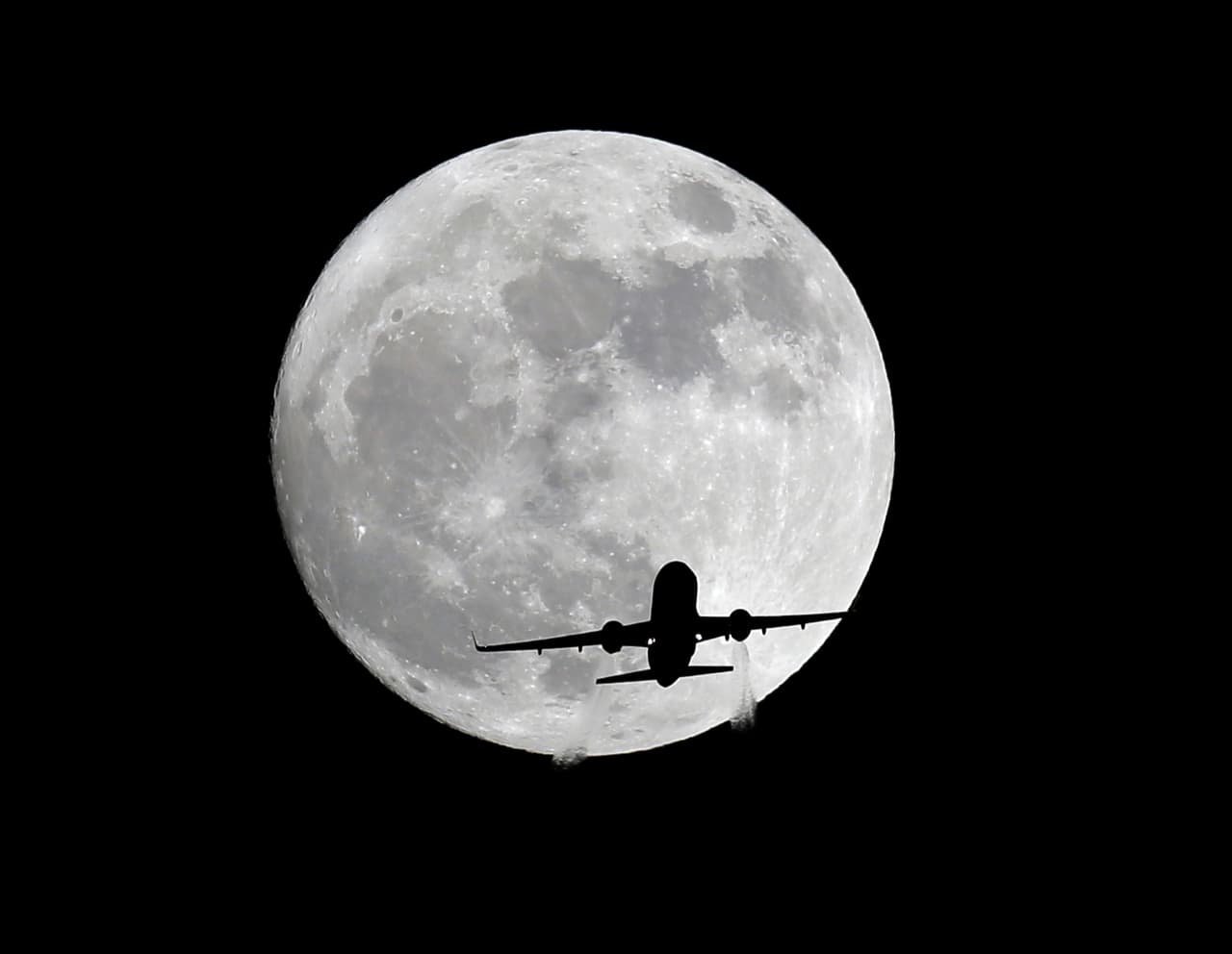 Un avión de pasajeros de American Airlines pasa frente a la Luna, visto desde Whittier, California, el domingo 13 de noviembre de 2016. (AP Foto/Nick Ut)