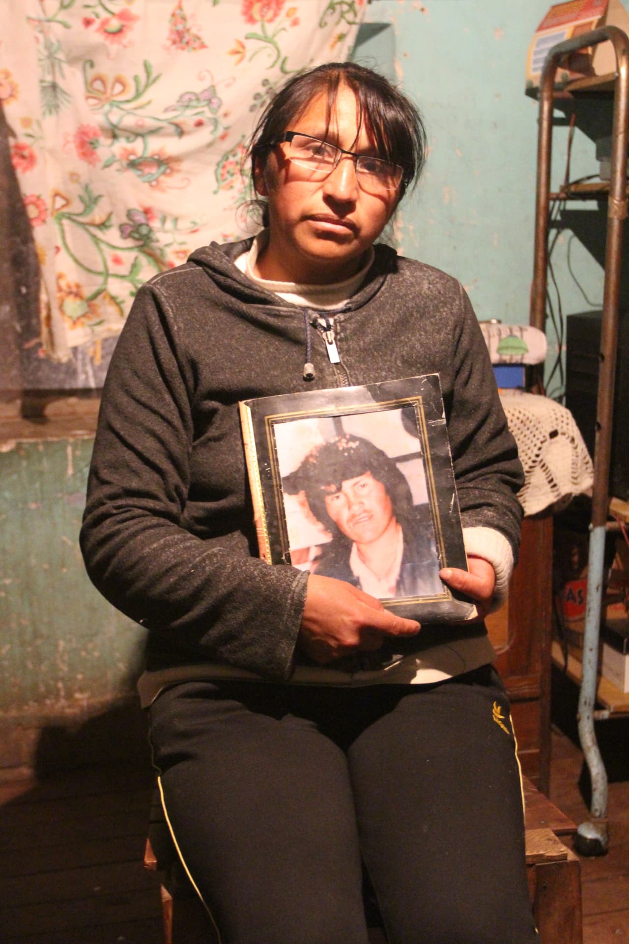 Vilma Menacho sujeta la foto de su difunto marido en su casa de un barrio de Potosí.